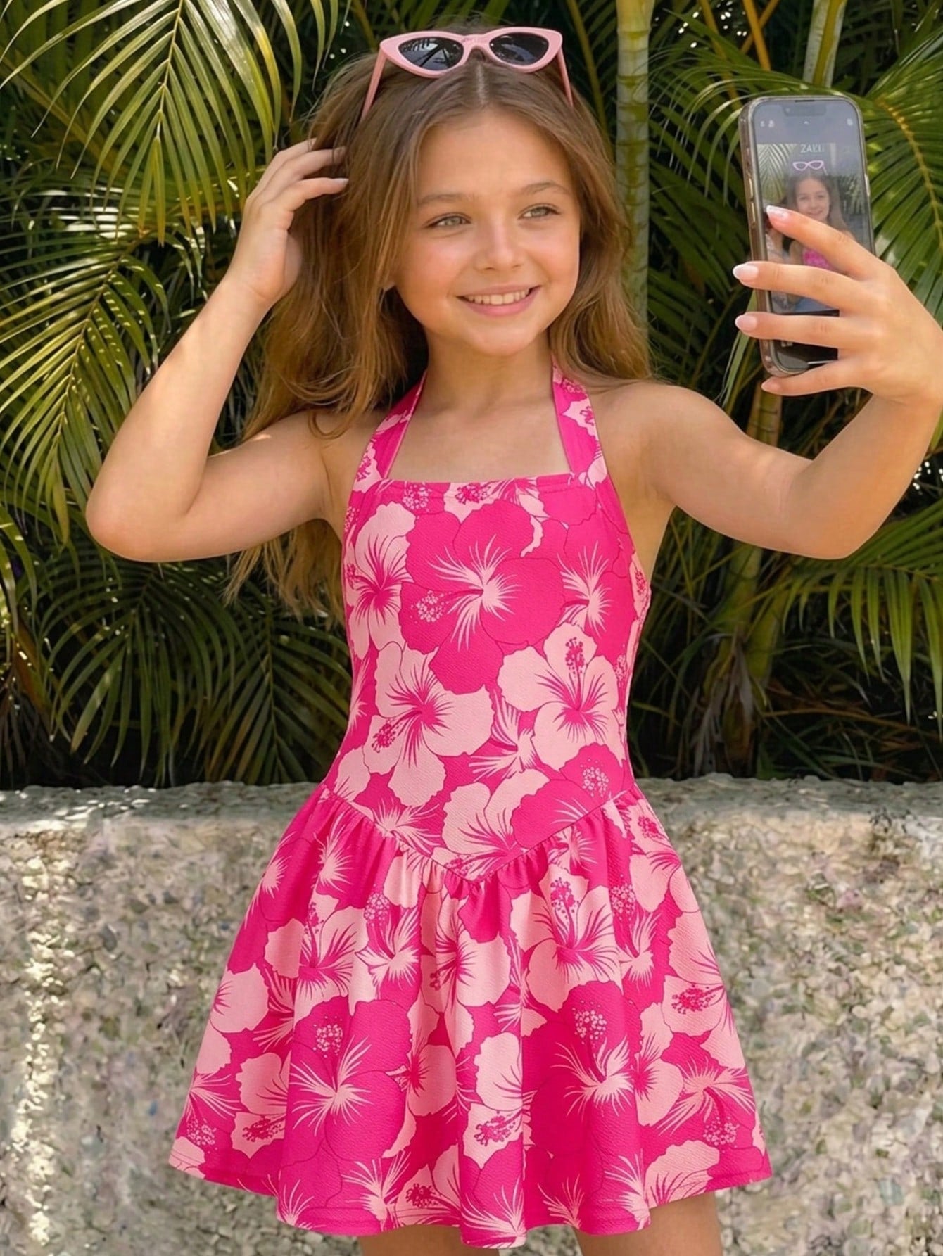 Black sleeveless halter polka dot mini dress for tween girls featuring a high waist and flared hem