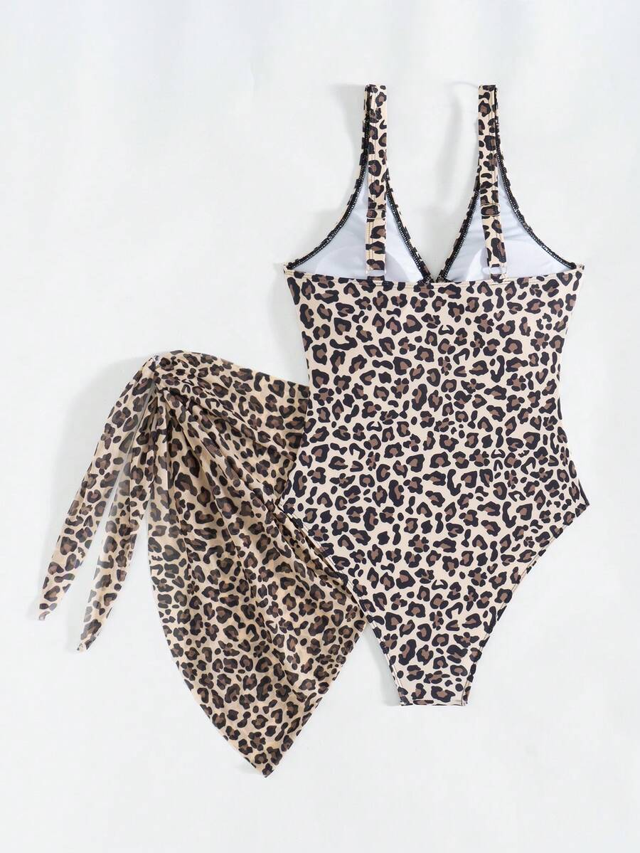 Women's black floral print plunge neck one-piece swimsuit featuring cut-out detail paired with a matching knee-length mesh cover-up skirt