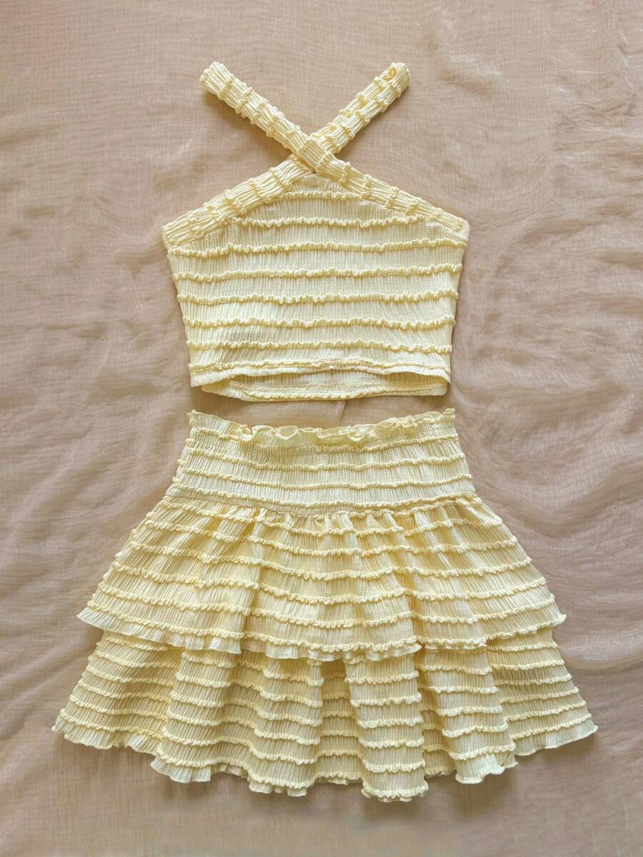 Tween girls blue and white 2-piece set with a striped halter neck vest top and a floral high-waist tiered paperbag skirt.
