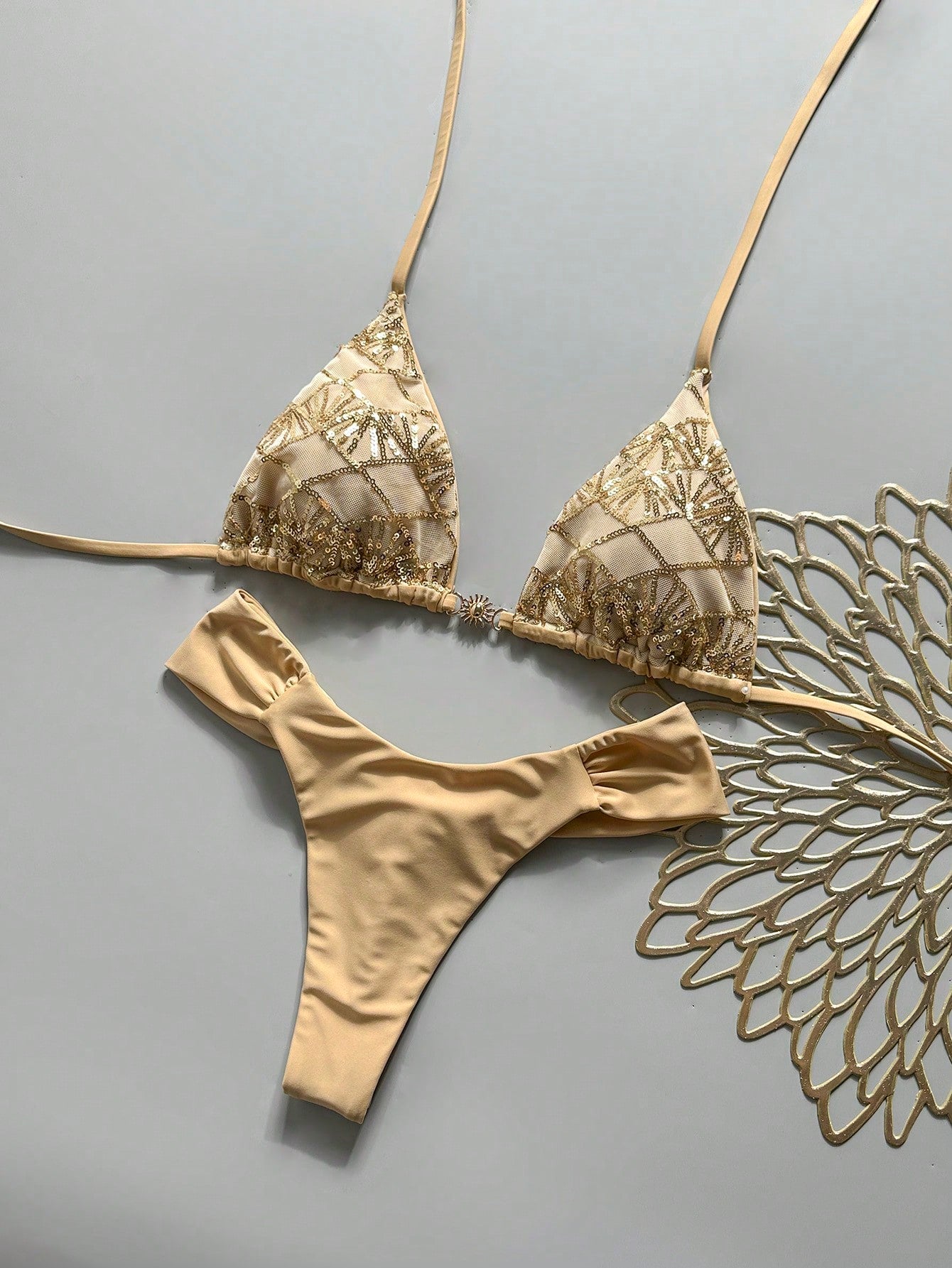 Women's 2-piece triangle cup bikini set in solid color featuring woven pearl shell decoration, halter neckline, and high-waist side-tie ruched bottoms.