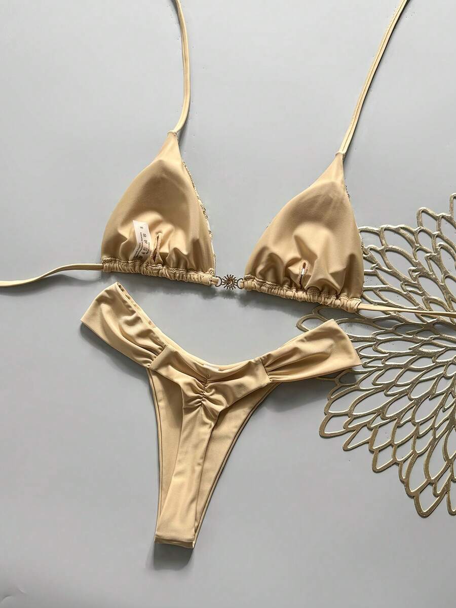 Women's 2-piece triangle cup bikini set in solid color featuring woven pearl shell decoration, halter neckline, and high-waist side-tie ruched bottoms.