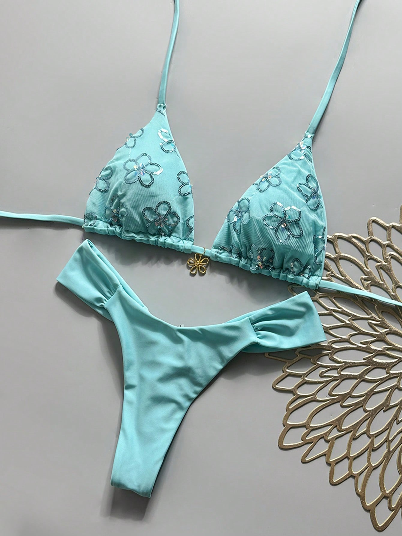 Women's 2-piece triangle cup bikini set in solid color featuring woven pearl shell decoration, halter neckline, and high-waist side-tie ruched bottoms.