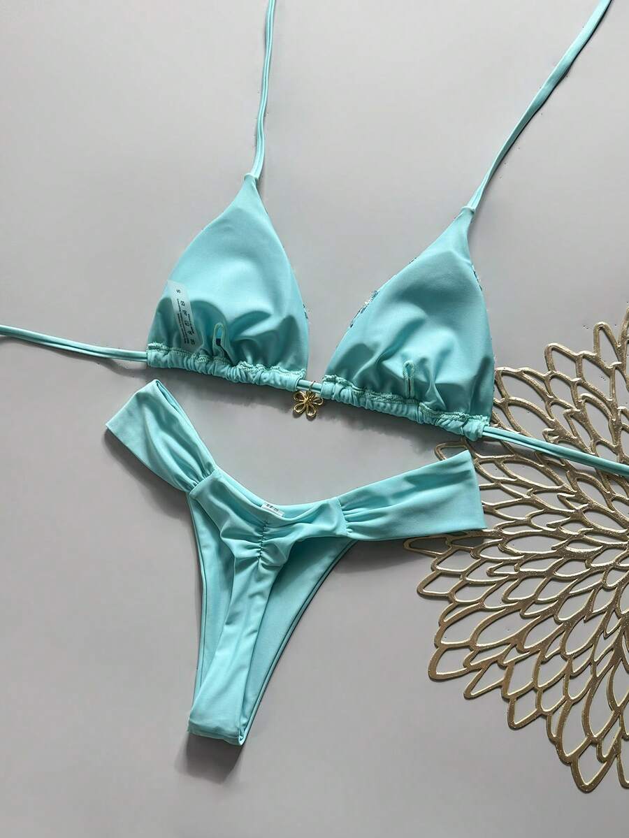 Women's 2-piece triangle cup bikini set in solid color featuring woven pearl shell decoration, halter neckline, and high-waist side-tie ruched bottoms.