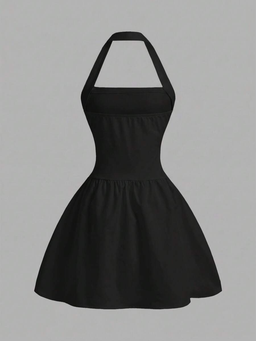 Black sleeveless halter polka dot mini dress for tween girls featuring a high waist and flared hem