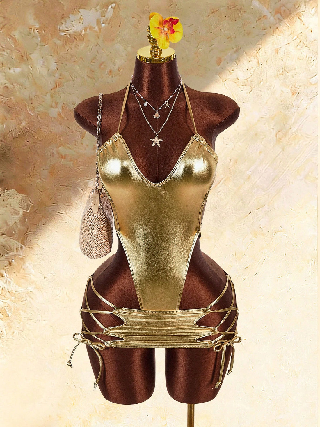 Gold women's knitted halter one-piece swimsuit set featuring a backless tie-back top and a matching mini skirt.