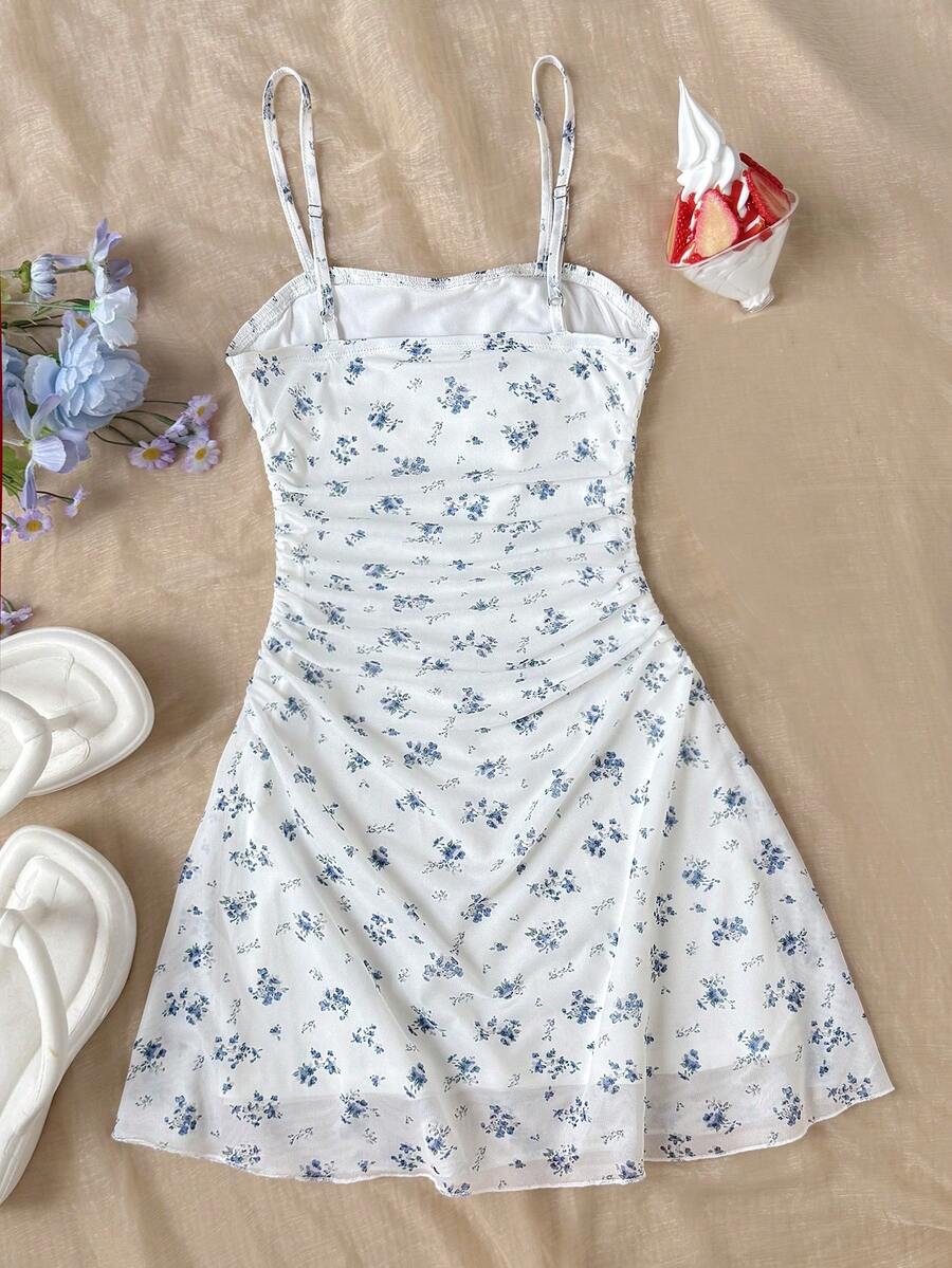 Tween girl yellow mini sundress with large pink floral hibiscus print, spaghetti straps, high waist, flared hem, and sleeveless cami style for summer beach wear