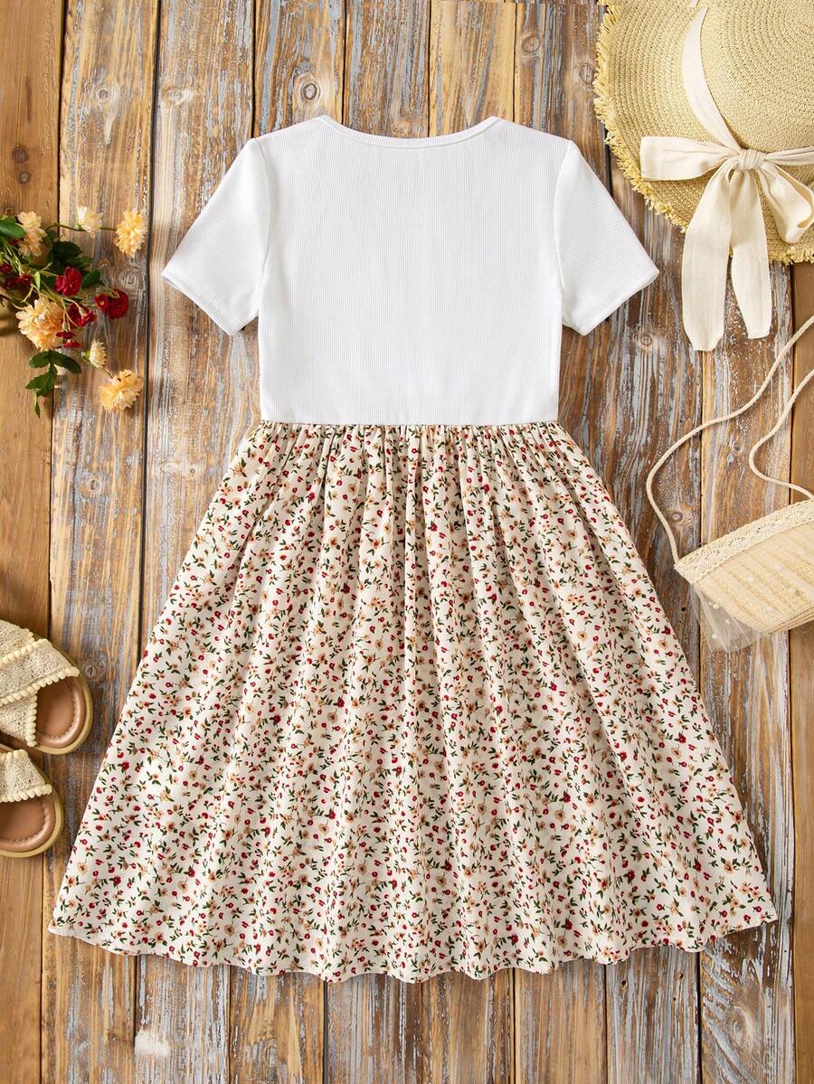 Tween girl wearing an apricot short sleeve A-line dress featuring a round neck, high waist with a belt, and flared hem.