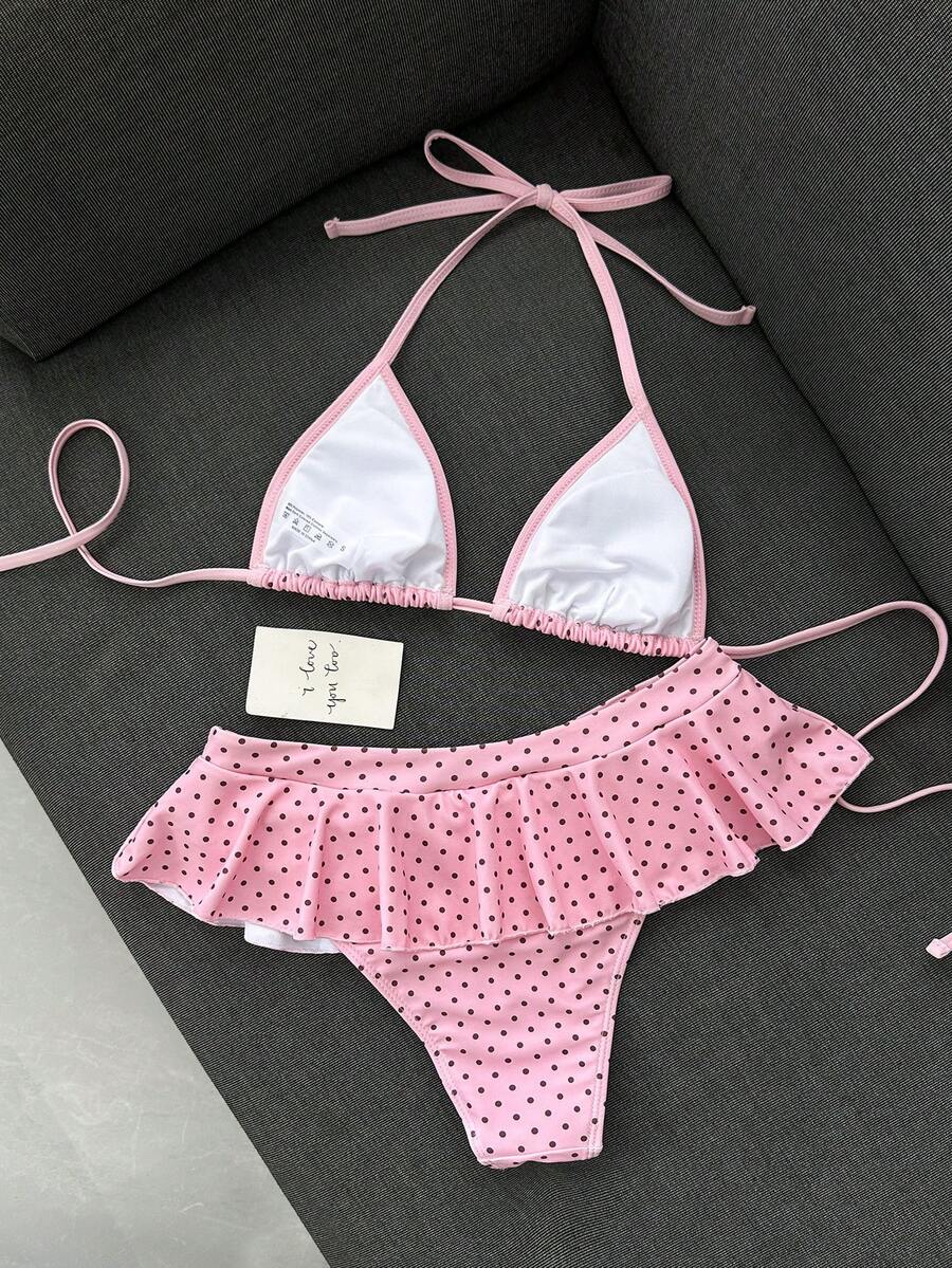 Women's 70s retro black and white polka dot bikini set featuring a halter triangle top and ultra low waist bottoms.