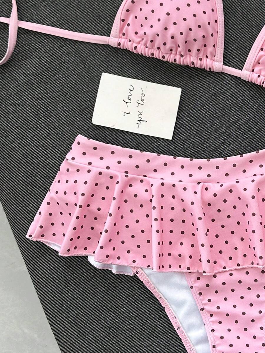 Women's 70s retro black and white polka dot bikini set featuring a halter triangle top and ultra low waist bottoms.