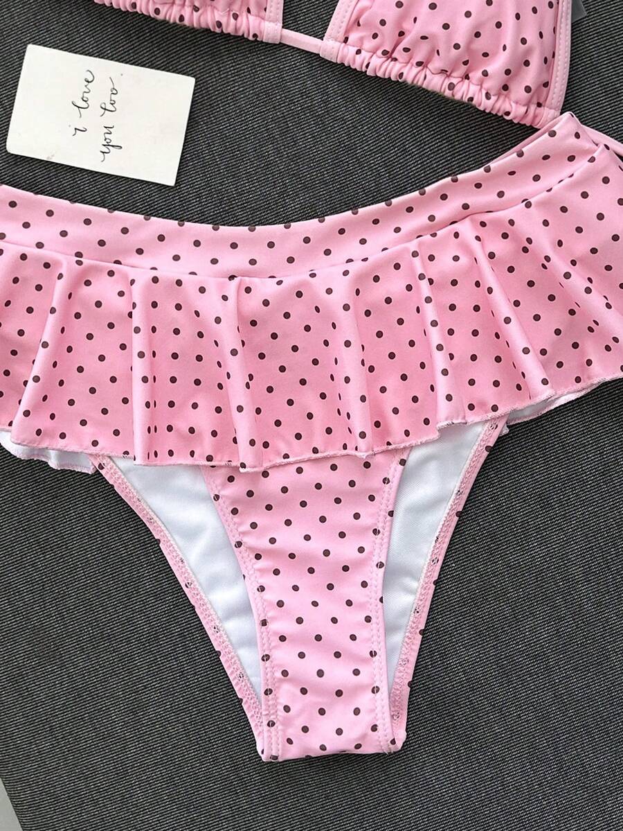 Women's 70s retro black and white polka dot bikini set featuring a halter triangle top and ultra low waist bottoms.