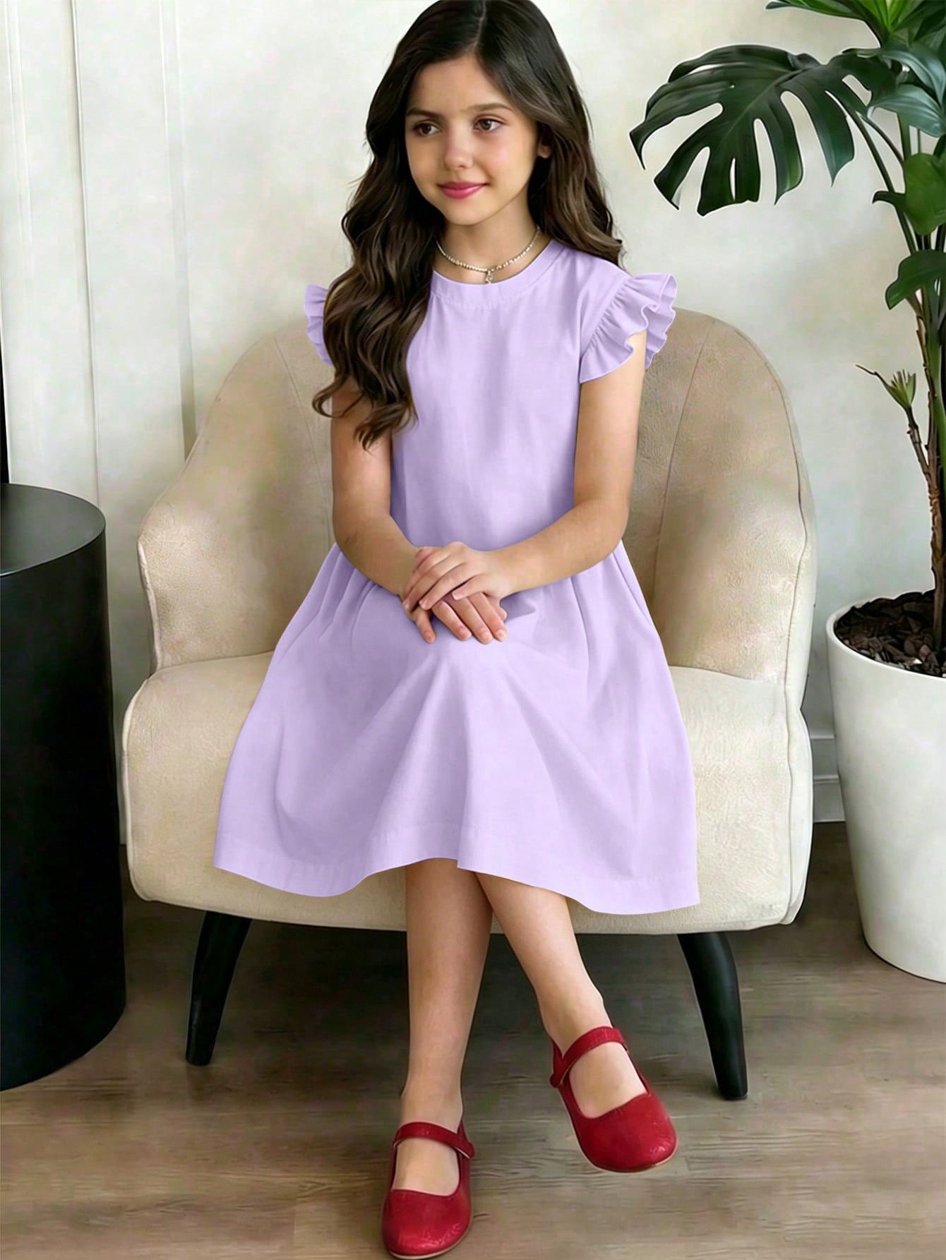 Girls black ruffle sleeve midi dress featuring a loose fit tunic silhouette, round neckline, button details, and short flounce sleeves.