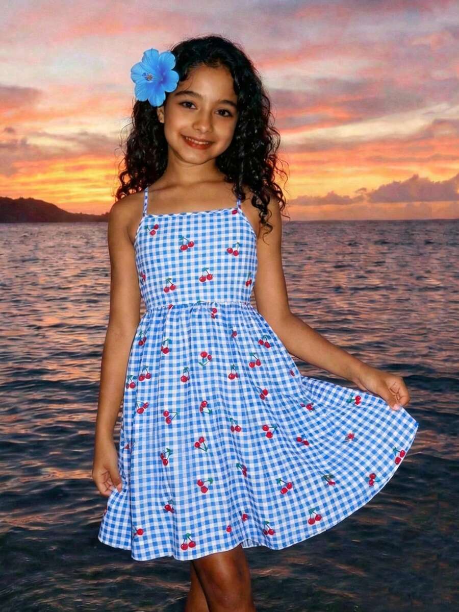 Tween girl wearing an apricot floral print sleeveless mini cami dress featuring spaghetti straps, a shirred high waist, flounce hem, and a bow back detail.
