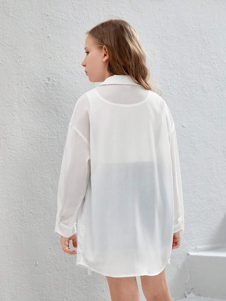 Front view of a white drop shoulder button-front long sleeve shirt for tween girls featuring a collar neckline and asymmetrical hem.