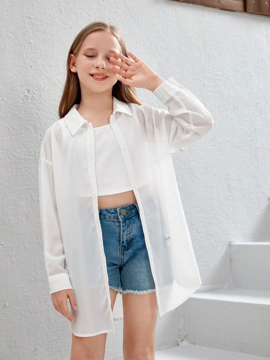 Front view of a white drop shoulder button-front long sleeve shirt for tween girls featuring a collar neckline and asymmetrical hem.