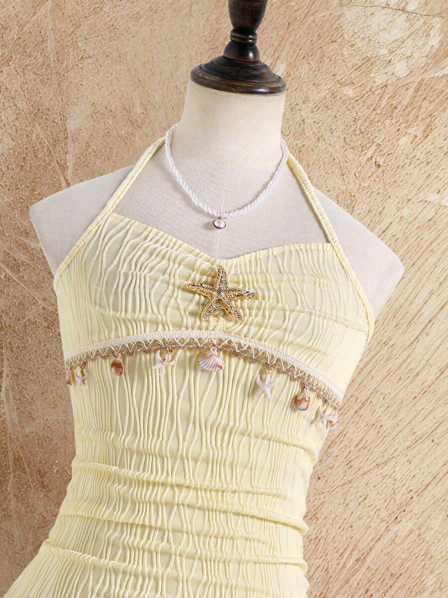 Tween girls apricot sleeveless halter mini dress with textured starfish and shell decor, shirred tiered layer, high waist, and flounce hem.