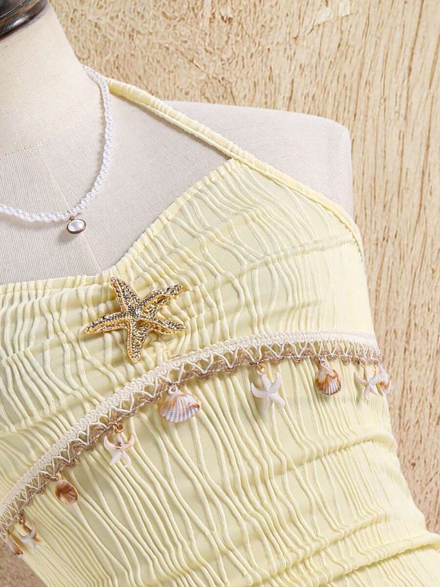 Tween girls apricot sleeveless halter mini dress with textured starfish and shell decor, shirred tiered layer, high waist, and flounce hem.
