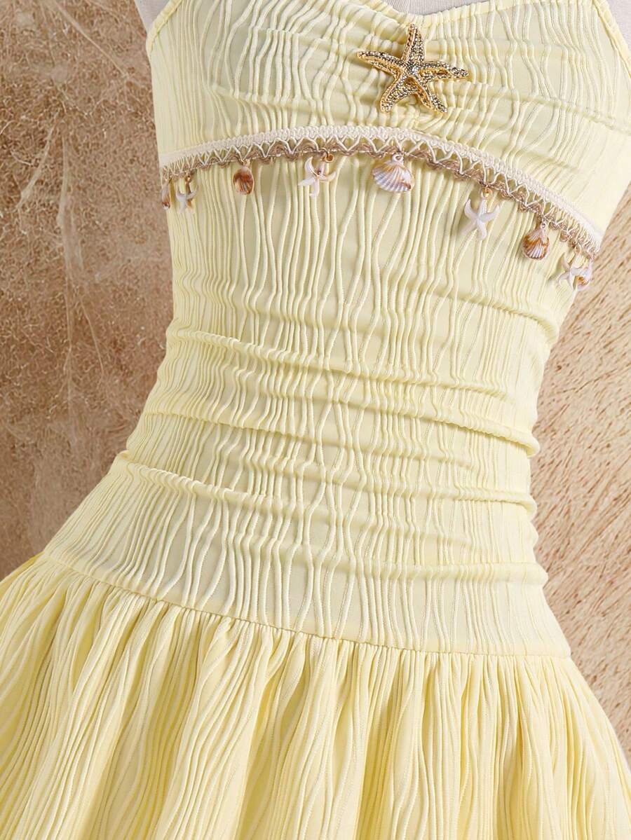 Tween girls apricot sleeveless halter mini dress with textured starfish and shell decor, shirred tiered layer, high waist, and flounce hem.