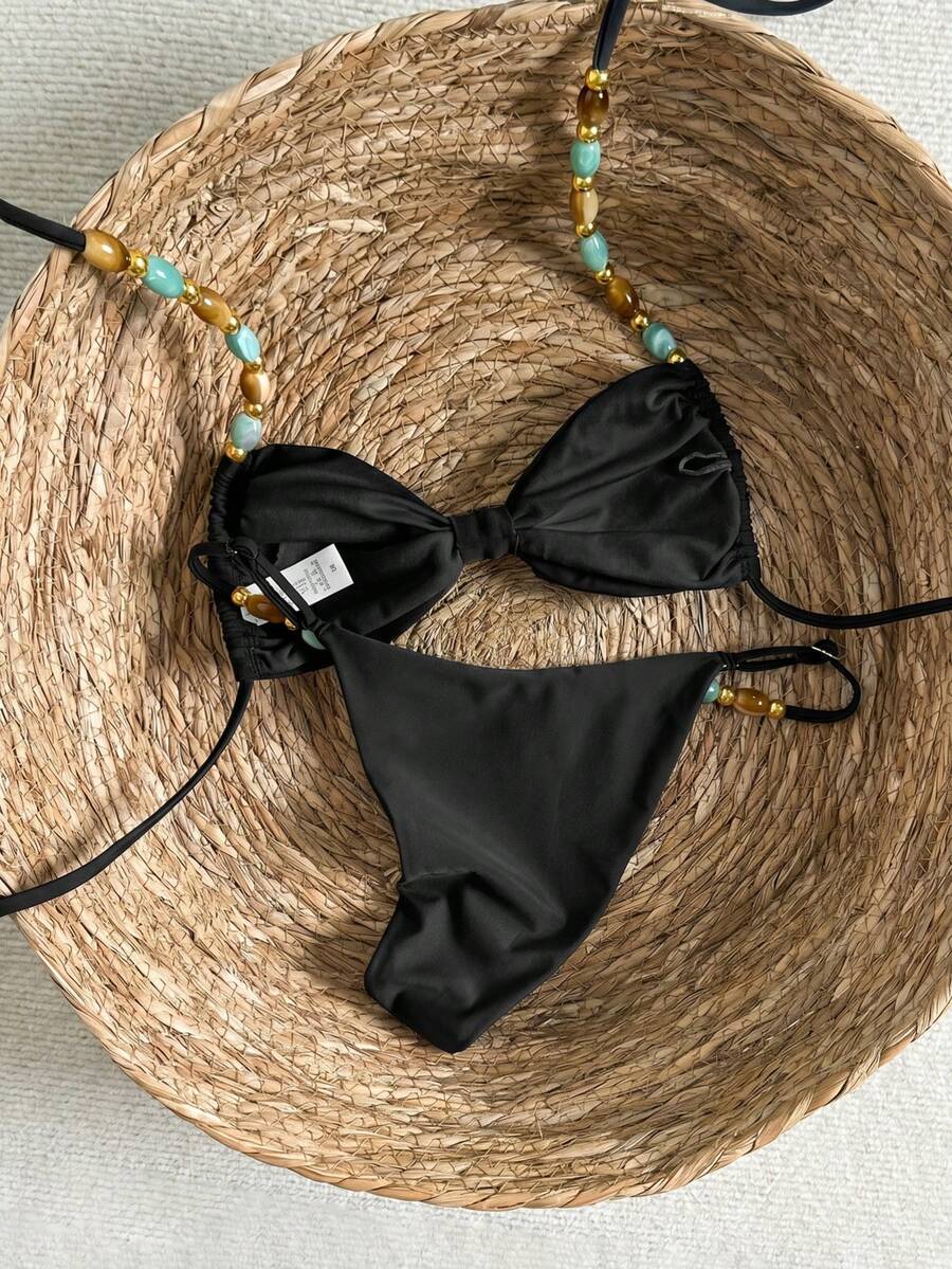 Women's green halter neck bikini set featuring color-block beaded shoulder straps, back tie detail, and high cut bottoms.