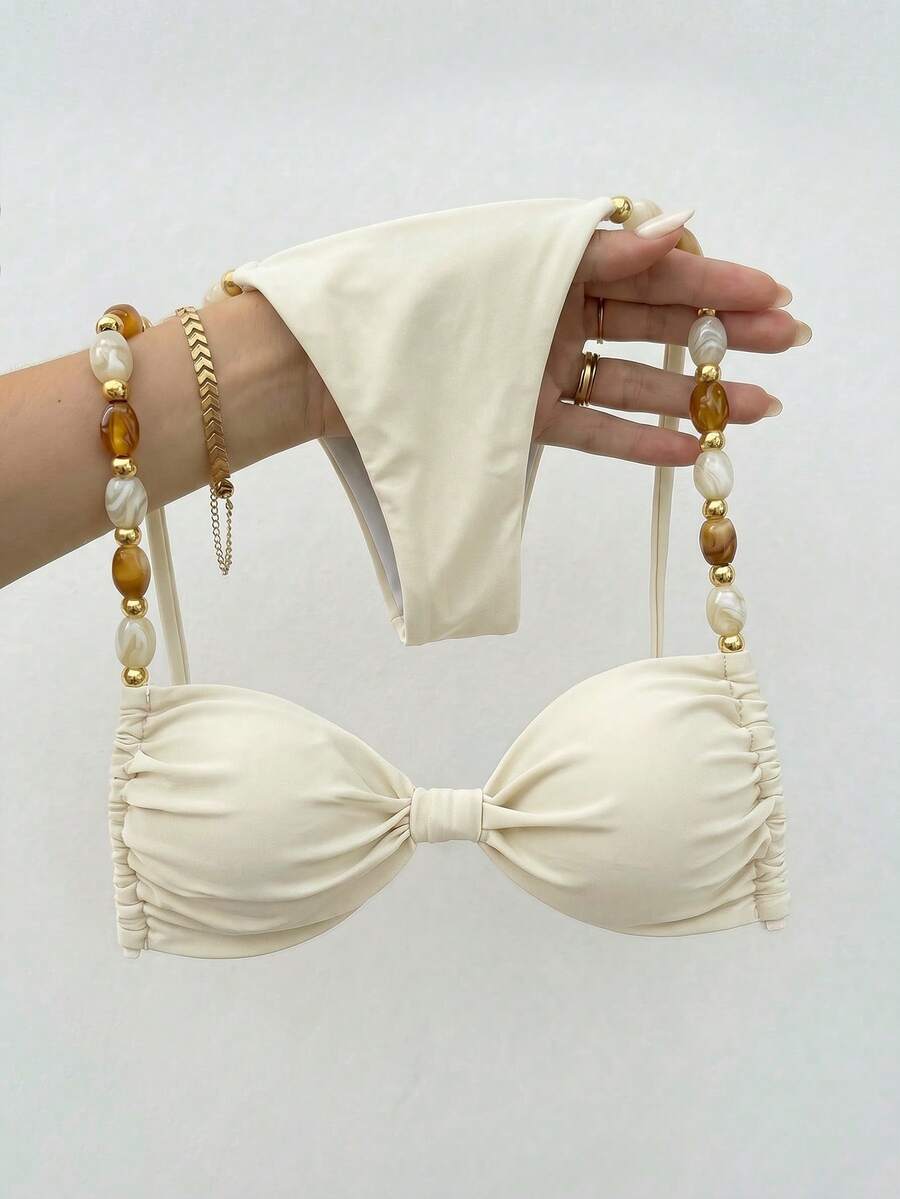 Women's green halter neck bikini set featuring color-block beaded shoulder straps, back tie detail, and high cut bottoms.