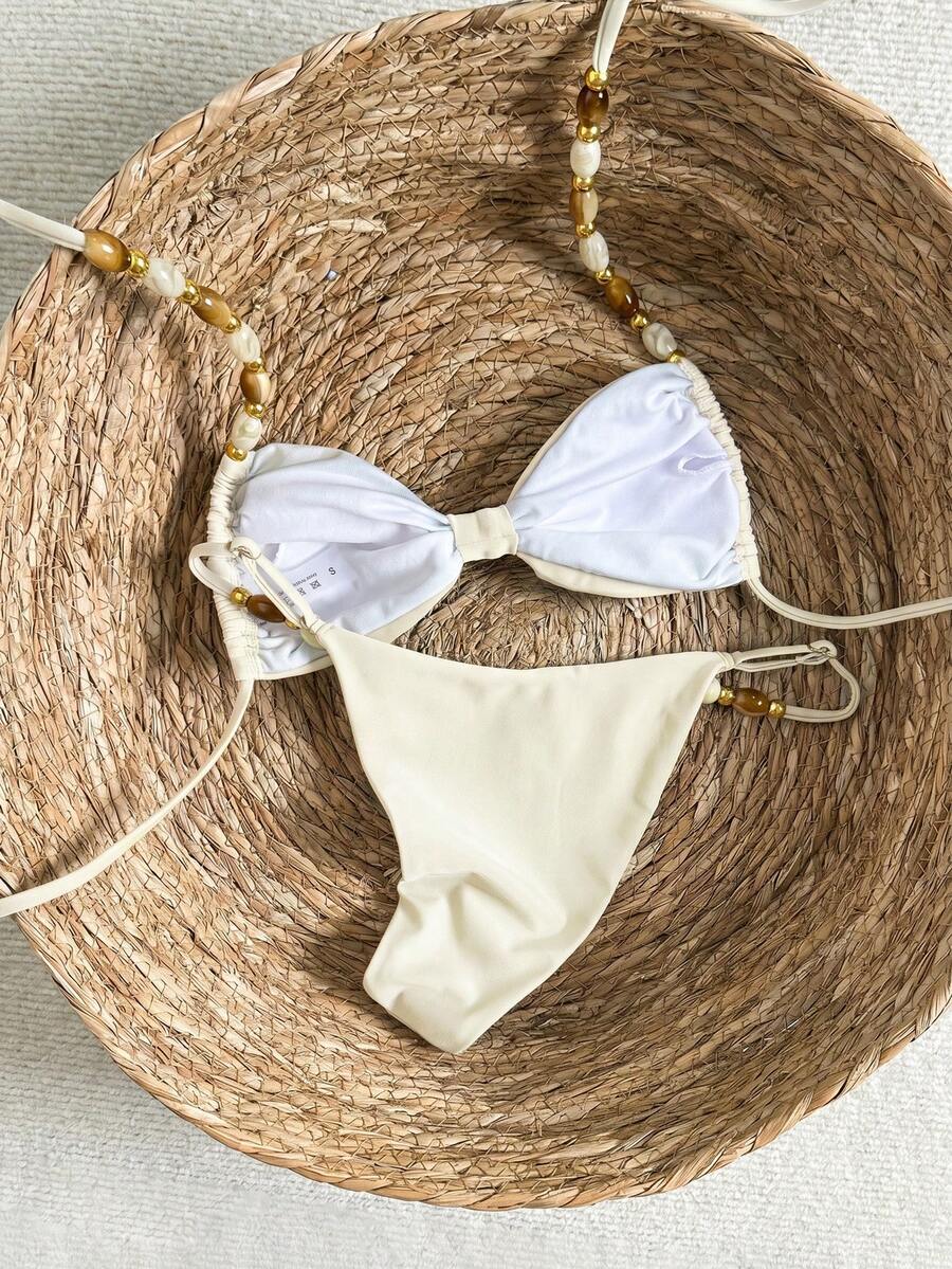 Women's green halter neck bikini set featuring color-block beaded shoulder straps, back tie detail, and high cut bottoms.