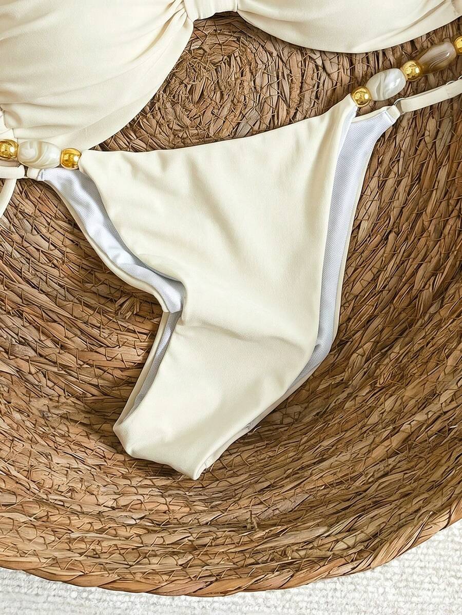 Women's green halter neck bikini set featuring color-block beaded shoulder straps, back tie detail, and high cut bottoms.
