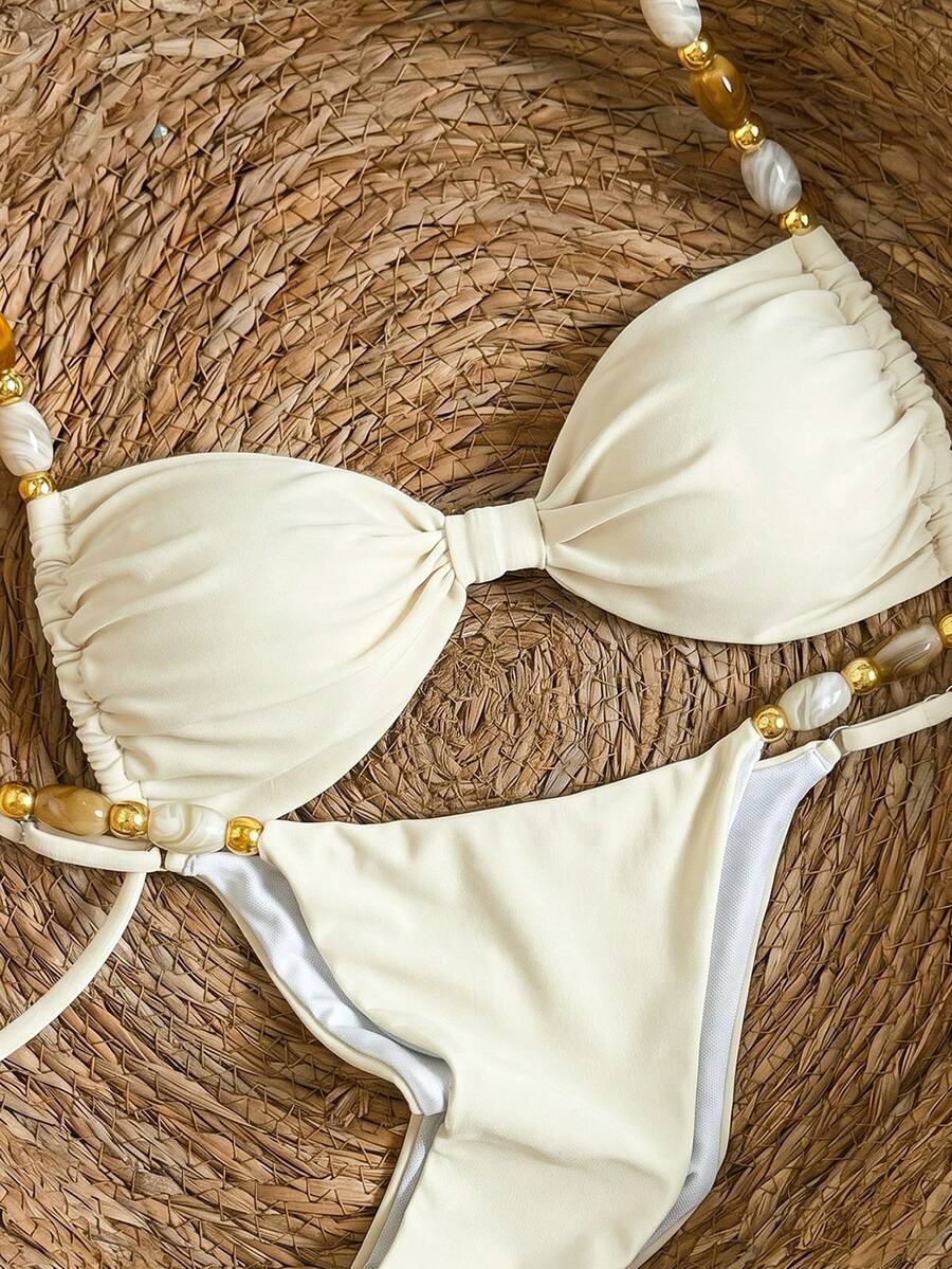 Women's green halter neck bikini set featuring color-block beaded shoulder straps, back tie detail, and high cut bottoms.