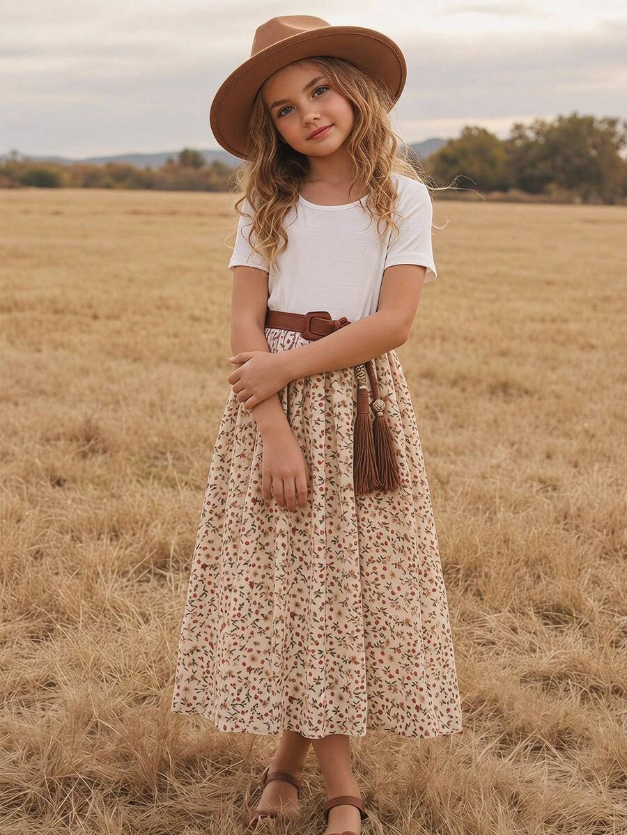Tween girl wearing an apricot short sleeve A-line dress featuring a round neck, high waist with a belt, and flared hem.