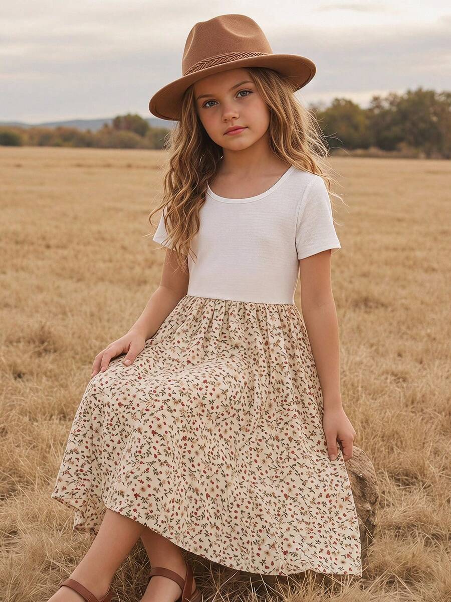 Tween girl wearing an apricot short sleeve A-line dress featuring a round neck, high waist with a belt, and flared hem.