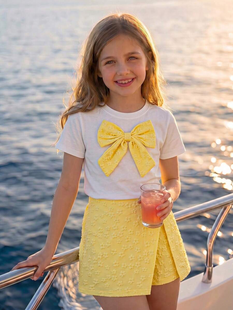 Tween girls 2-piece blue outfit featuring a short sleeve round neck t-shirt with a bow front detail and an asymmetric wrap skort.