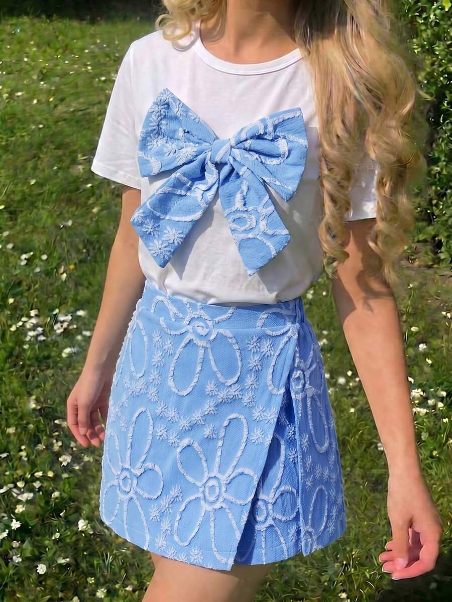 Tween girls 2-piece blue outfit featuring a short sleeve round neck t-shirt with a bow front detail and an asymmetric wrap skort.