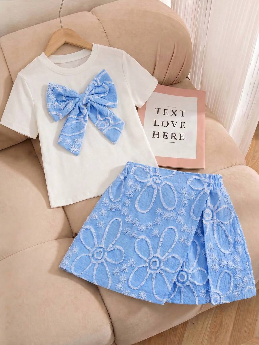 Tween girls 2-piece blue outfit featuring a short sleeve round neck t-shirt with a bow front detail and an asymmetric wrap skort.