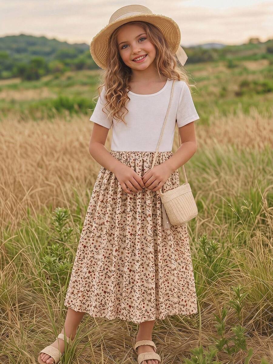 Tween girl wearing an apricot short sleeve A-line dress featuring a round neck, high waist with a belt, and flared hem.