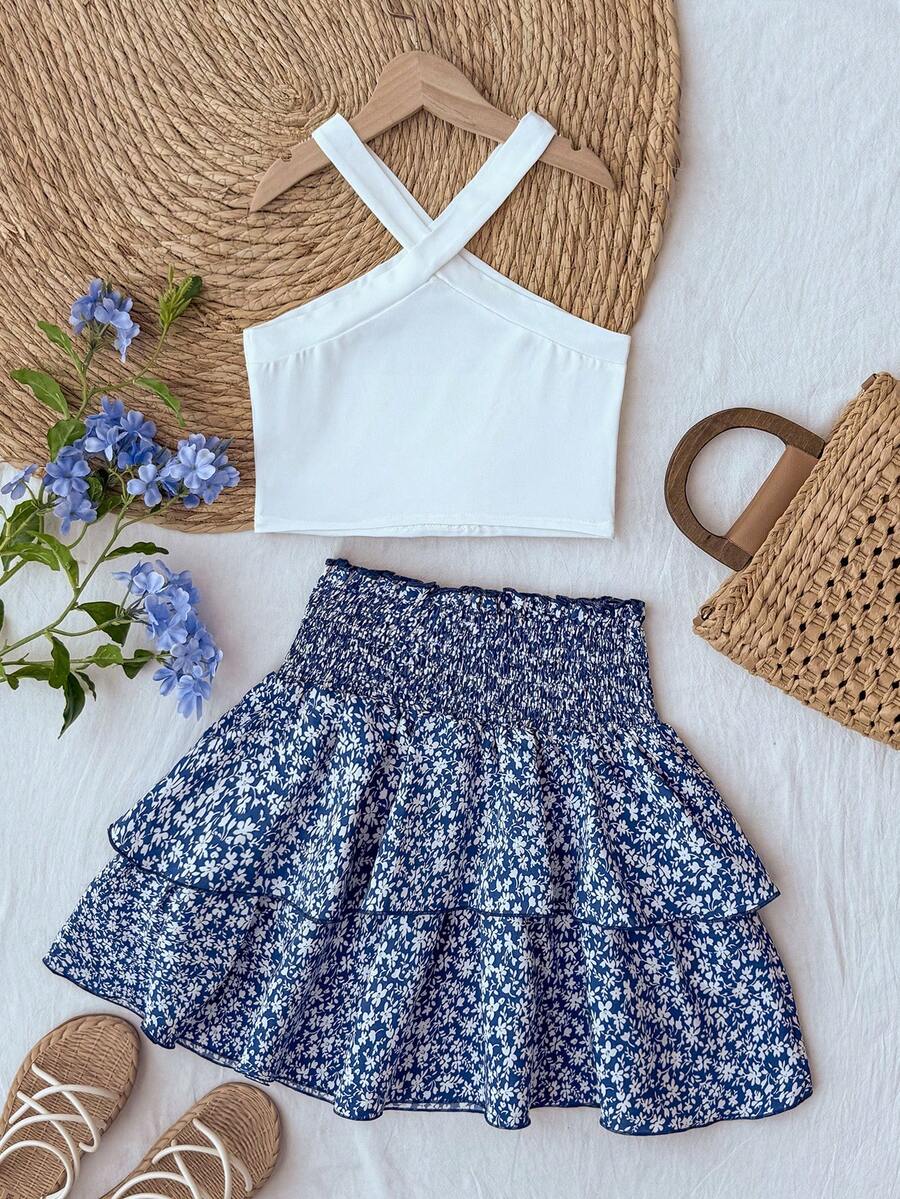 Tween girls blue and white 2-piece set with a striped halter neck vest top and a floral high-waist tiered paperbag skirt.