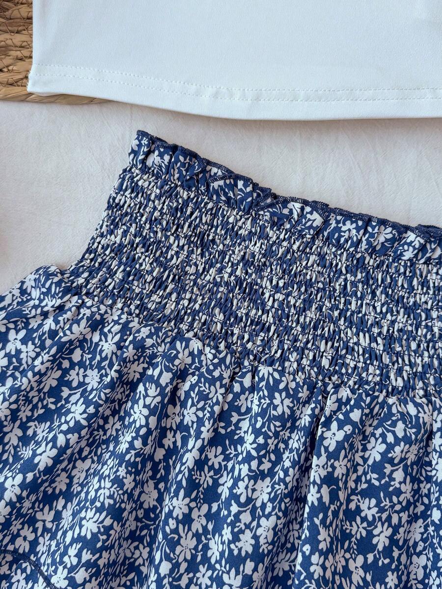 Tween girls blue and white 2-piece set with a striped halter neck vest top and a floral high-waist tiered paperbag skirt.