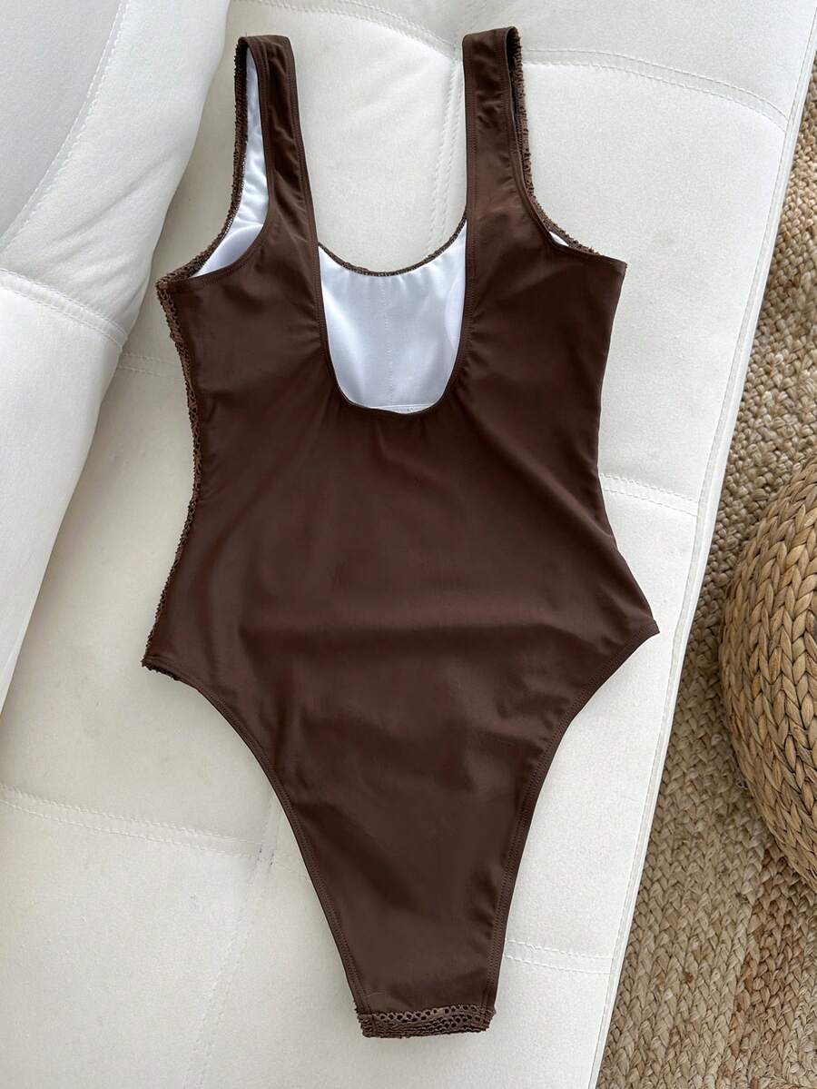 Women's solid color one-piece swimsuit featuring a backless scoop neck design and high cut fit