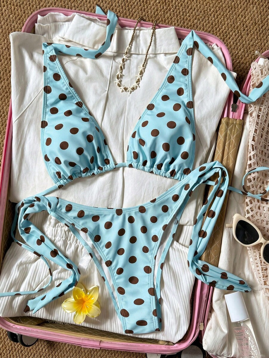 Women's polka dot two-piece bikini set featuring a backless halter top with triangle cups and matching tie-side bottoms.