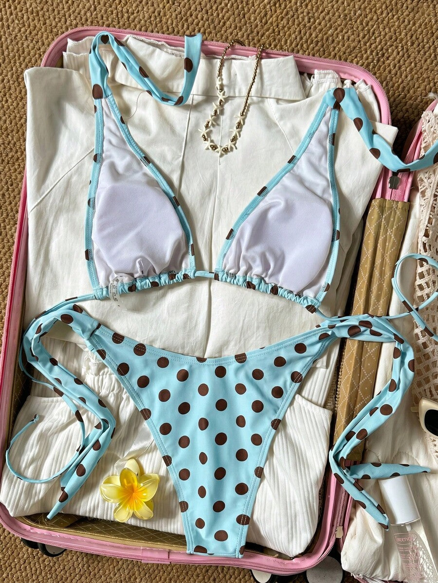 Women's polka dot two-piece bikini set featuring a backless halter top with triangle cups and matching tie-side bottoms.