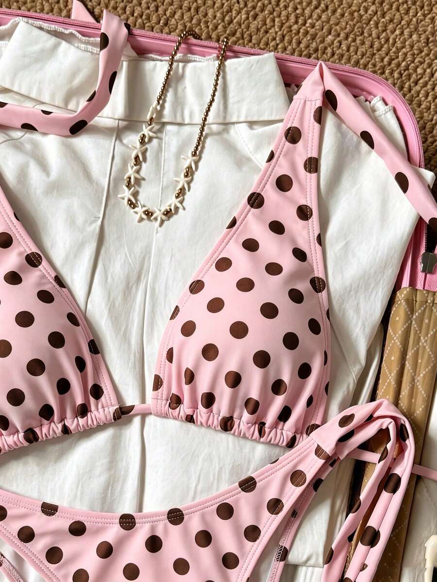 Women's polka dot two-piece bikini set featuring a backless halter top with triangle cups and matching tie-side bottoms.