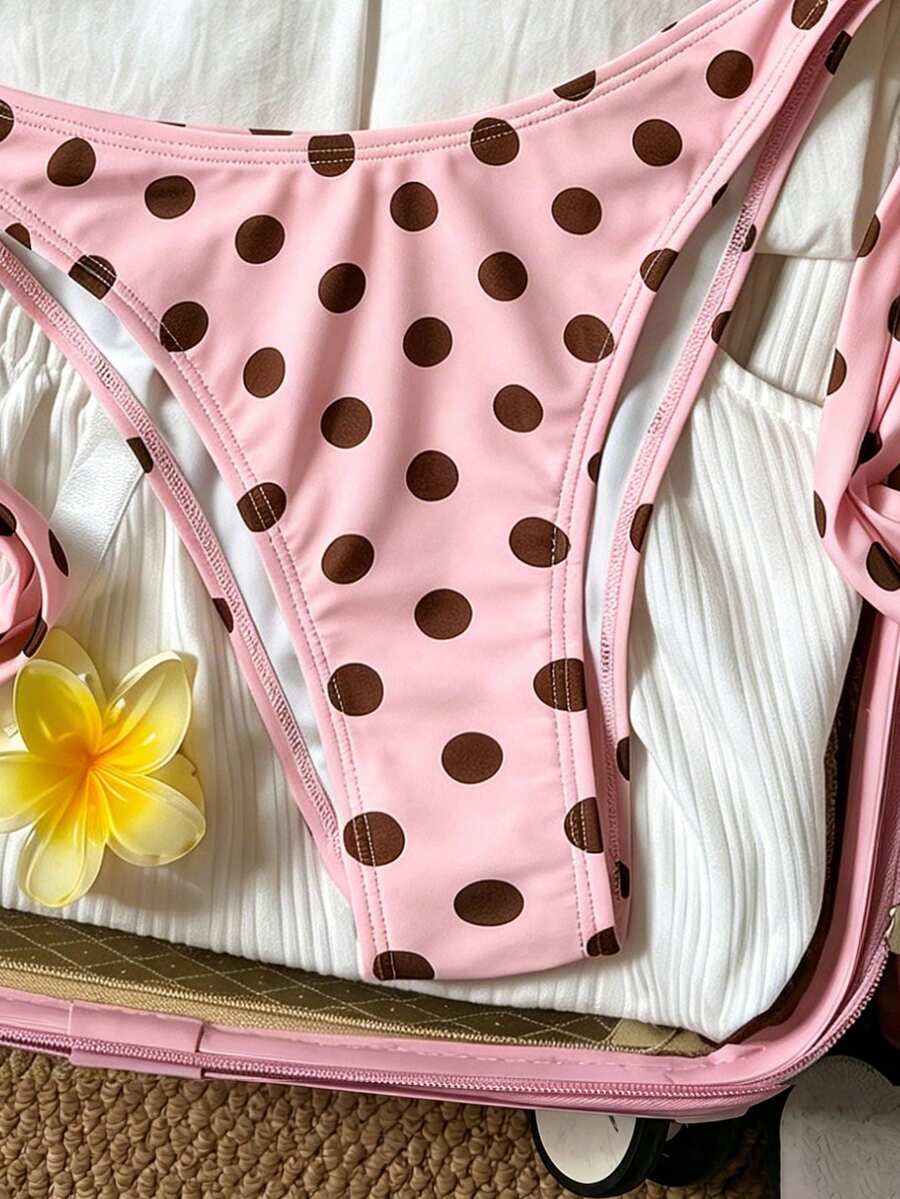 Women's polka dot two-piece bikini set featuring a backless halter top with triangle cups and matching tie-side bottoms.