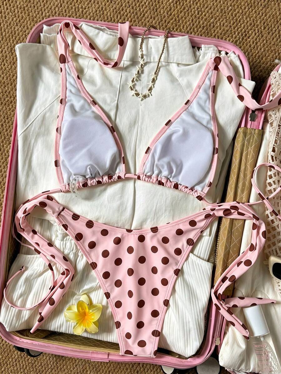 Women's polka dot two-piece bikini set featuring a backless halter top with triangle cups and matching tie-side bottoms.