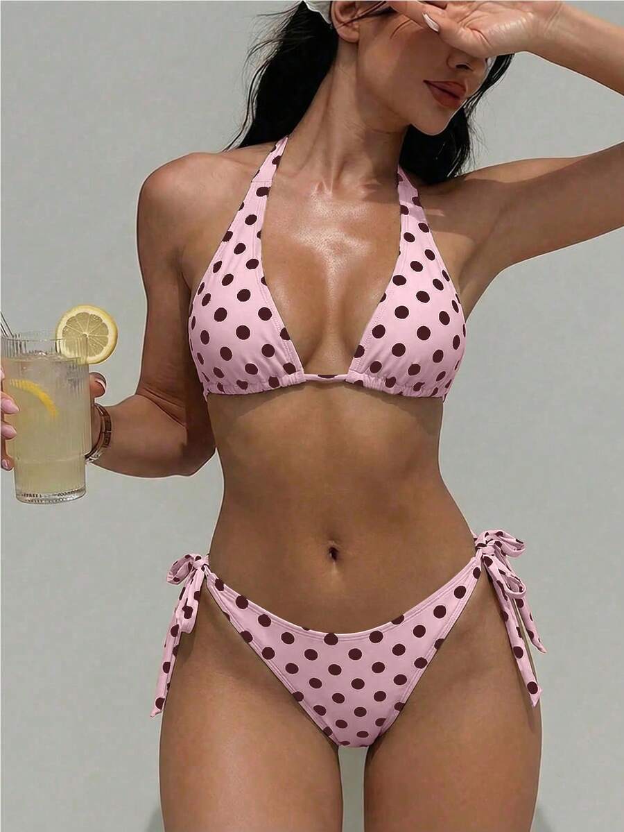 Women's polka dot two-piece bikini set featuring a backless halter top with triangle cups and matching tie-side bottoms.