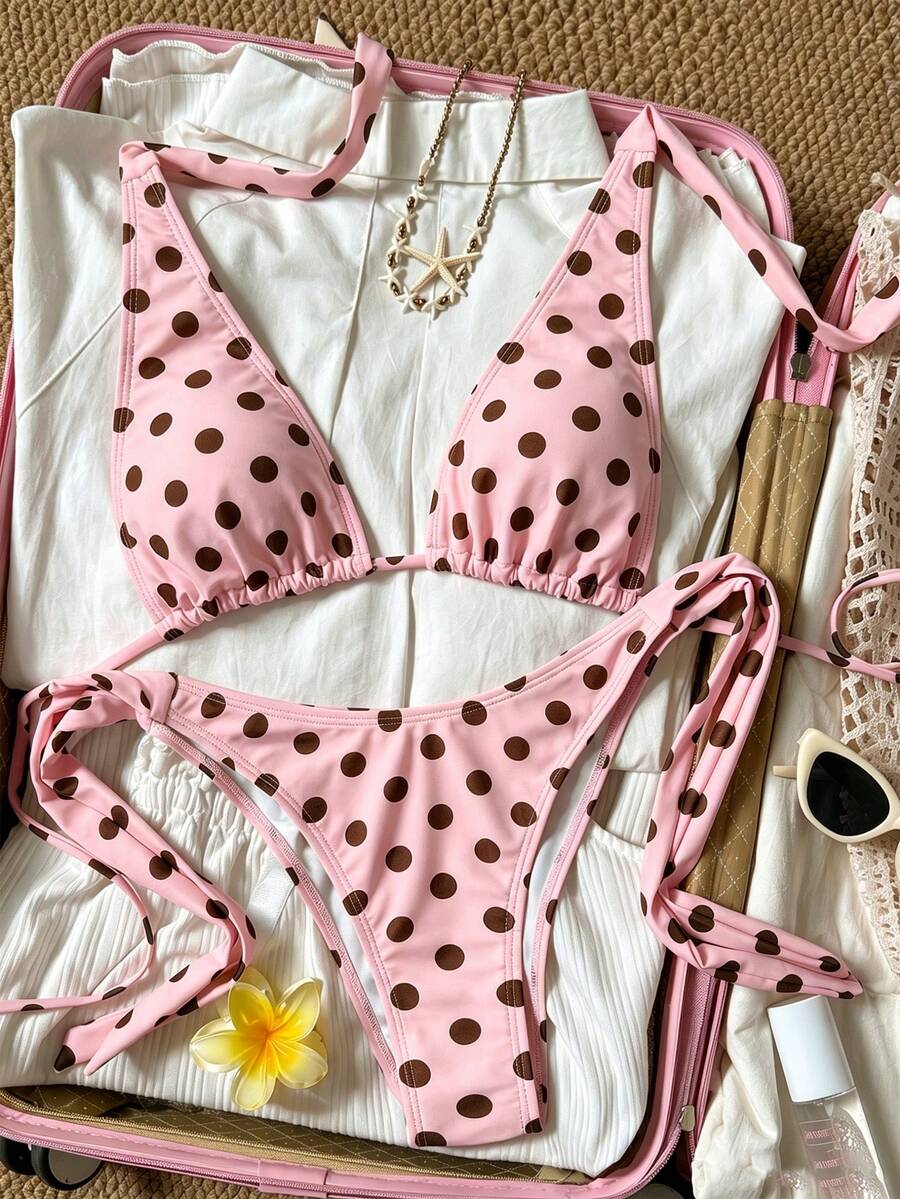 Women's polka dot two-piece bikini set featuring a backless halter top with triangle cups and matching tie-side bottoms.