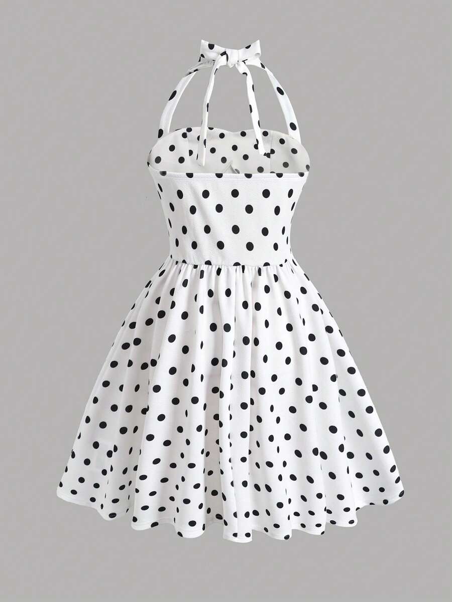 Black and white polka dot cami dress for tween girls featuring a square neckline, high waist, and flared short A-line hem.