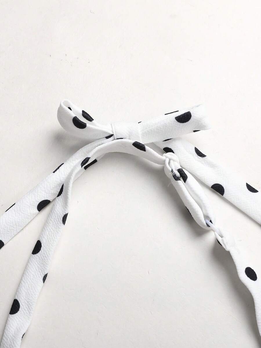 Black and white polka dot cami dress for tween girls featuring a square neckline, high waist, and flared short A-line hem.