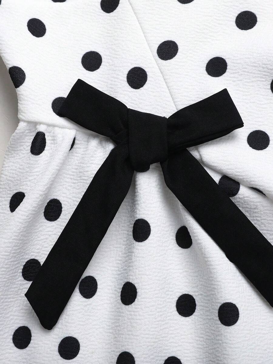 Black and white polka dot cami dress for tween girls featuring a square neckline, high waist, and flared short A-line hem.
