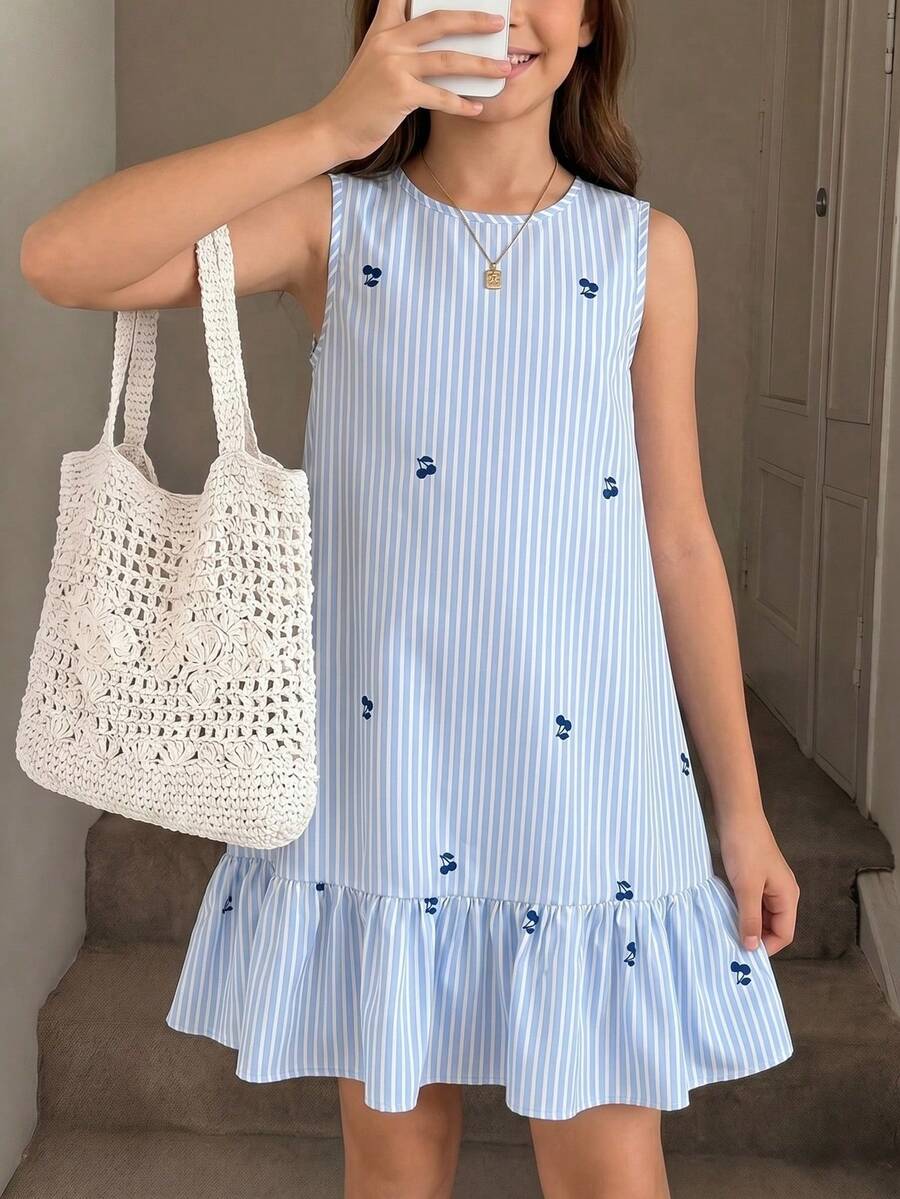 Tween girl wearing a sleeveless black tunic dress featuring a round neck, contrast lace details, and a straight hem.