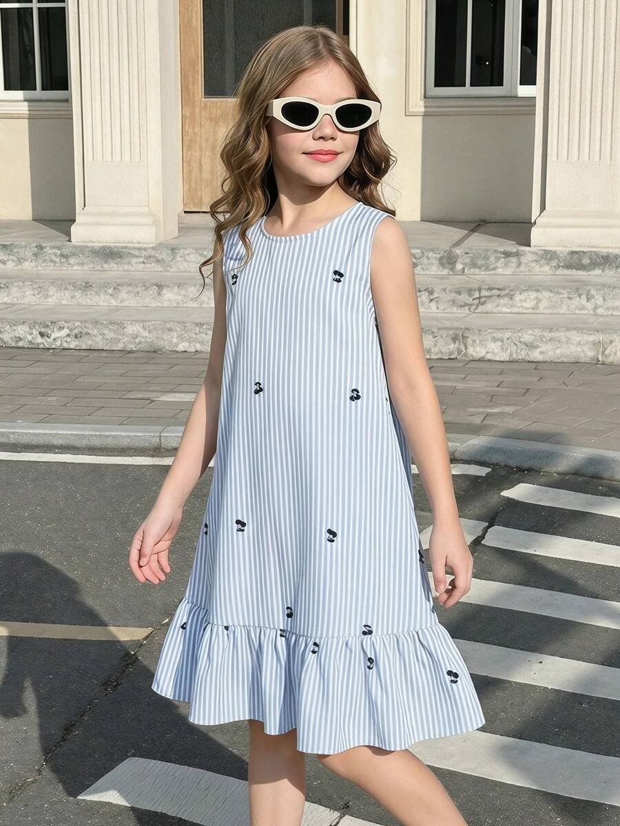 Tween girl wearing a sleeveless black tunic dress featuring a round neck, contrast lace details, and a straight hem.
