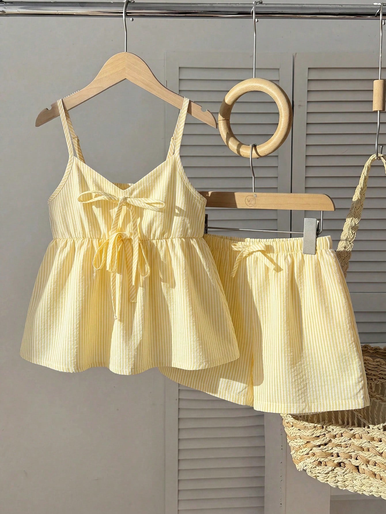Tween girl 2-piece summer set with a black and white sleeveless striped spaghetti strap tank top with ruffle details and matching casual shorts.