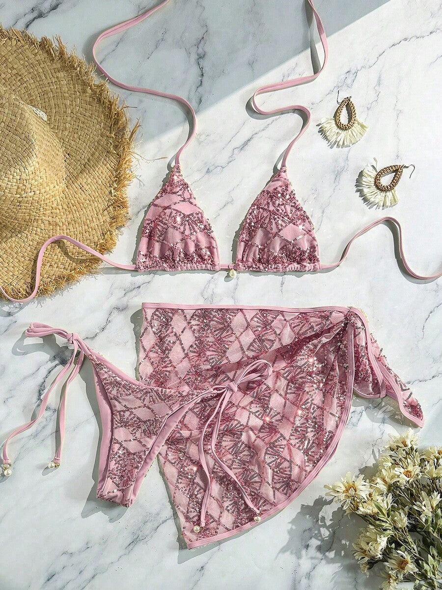 Women's 3-piece blue tropical shell print bikini set featuring a halter bralette top, low-waist tie-side bottom, and a matching sheer mesh cover-up skirt.