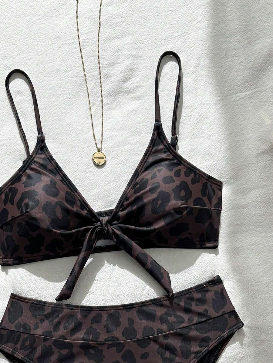 Women's black 2-piece high waist bikini swimsuit set featuring spaghetti straps, criss-cross knot details, wireless bra with removable padding, and high-stretch fabric.